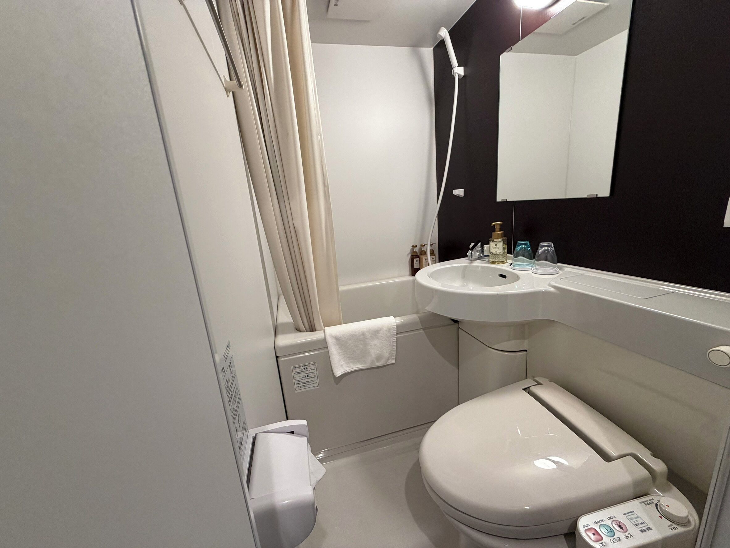 A modern bathroom with a toilet, sink, and shower.