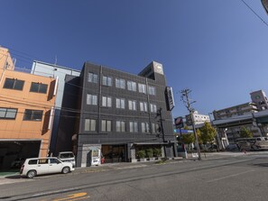 A multi-story building with a modern design, featuring a large entrance and a visible vending machine outside. - OSAKA PORT HOTEL L'ESPOIR (Osaka)