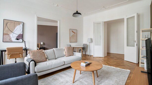 A modern living room with a sofa, coffee table, and a TV stand. - Tasteful Margareten 1BR, Fully Furnished & Equipped, by Blueground (Vienna)