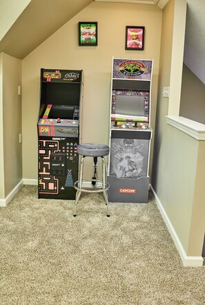 A retro gaming setup with arcade cabinets and a stool. - Welcome to Kings Palace2 (Memphis)
