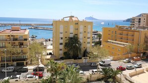 A coastal urban area with a prominent yellow building, a marina with boats, and a clear view of the sea. - 37C TB fantastic views (Calp)