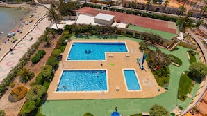 An aerial view of a resort with two swimming pools, a beach, and a building with a red roof. - 29D Spectacular views parking and wifi (Calp)