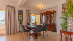 A dining area with a table, chairs, a chandelier, a cabinet, and a potted plant. - 29D Spectacular views parking and wifi (Calp)