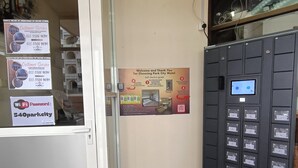 Zona de recepción de un hotel con un cartel guía de auto-registro, un letrero con la contraseña de Wi-Fi y un teclado de seguridad.