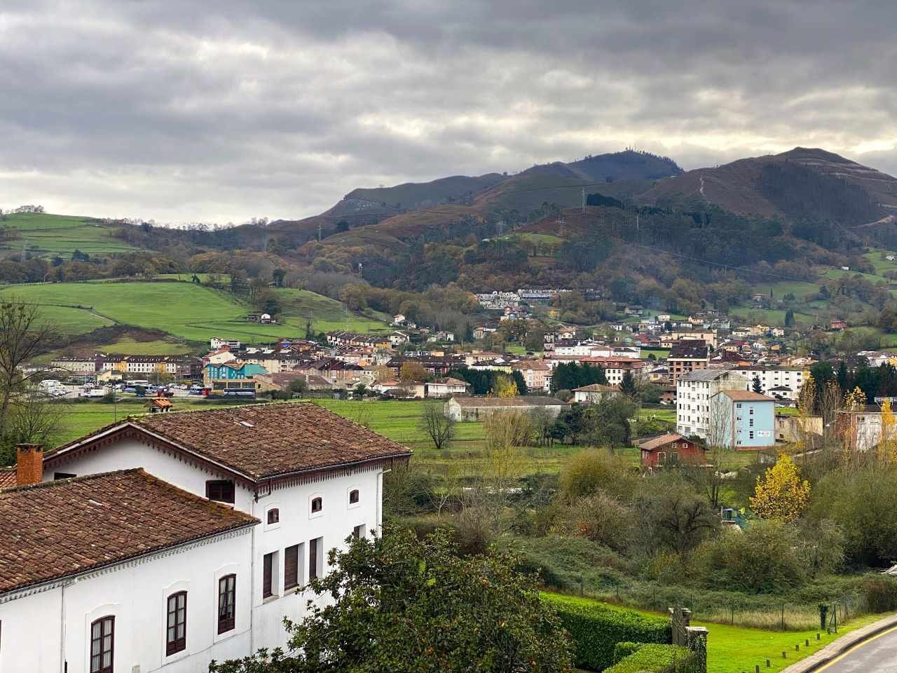 Un pueblo con edificios y un paisaje montañoso al fondo.