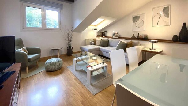 Un salon moderne avec une table basse en verre, un canapé et une table à manger.