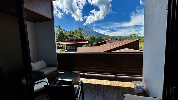 A balcony with a view of a mountain and a green landscape. - Arenal Monara (La Fortuna)
