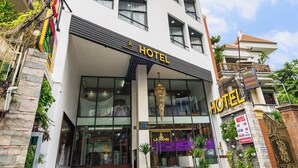 A modern hotel with a prominent 'HOTEL' sign, a glass entrance, and a staircase leading to the entrance. - Saigon Airport Hotel  (Ho Chi Minh City)