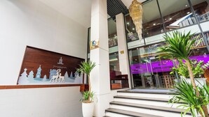 A hotel entrance with a modern design, featuring a large chandelier, steps leading to the entrance, and a sign indicating the hotel is located at Saigon Airport. - Saigon Airport Hotel  (Ho Chi Minh City)
