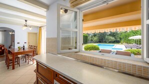 A kitchen with a large window overlooking a pool area. - Cozy home in Porec with WiFi (Porec)