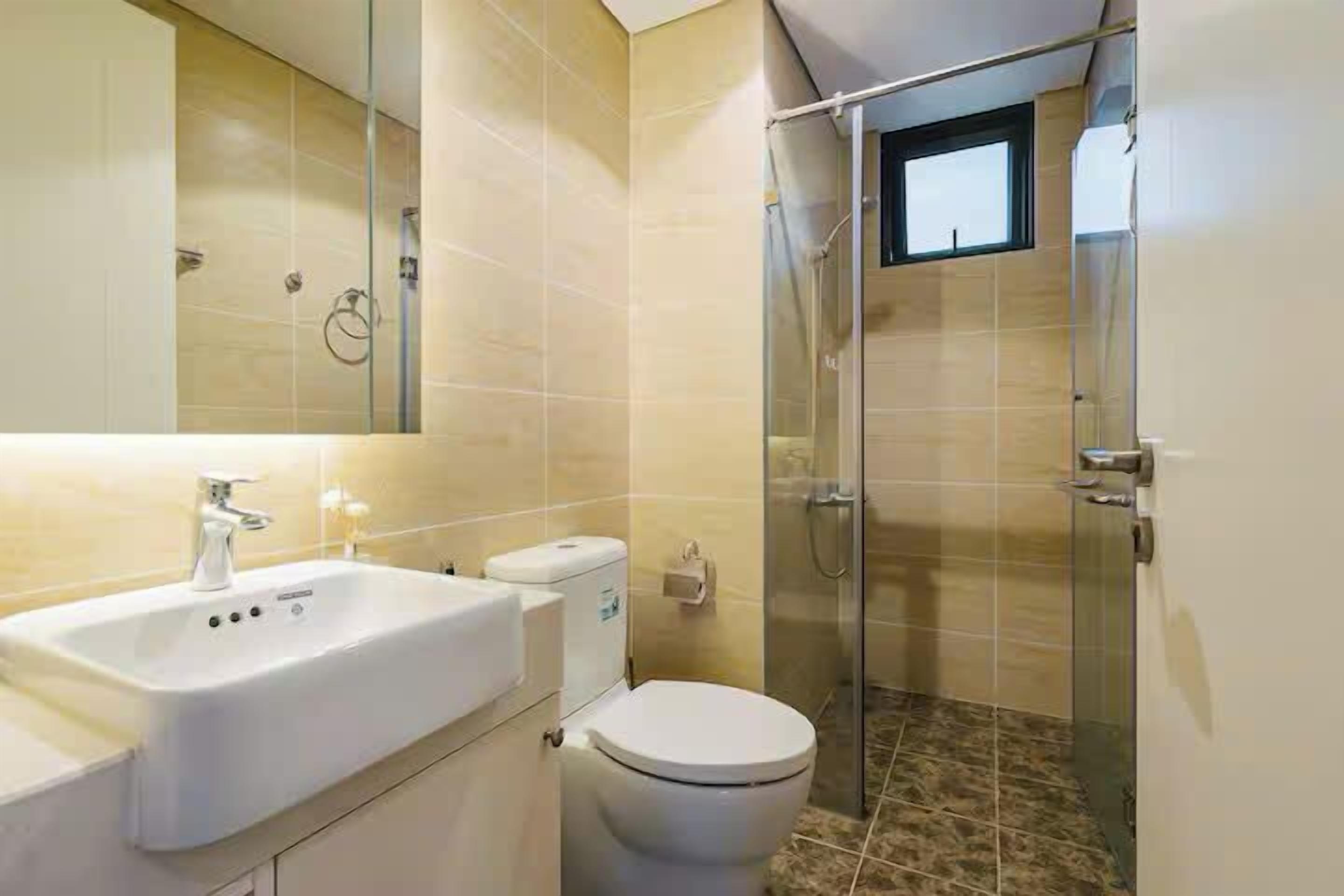 A bathroom with a sink, toilet, and glass shower enclosure.