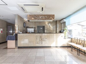 A hotel reception area with a marble counter, a clock, and a sign that reads "HOTEL HORAIRE SAITO". - Hotel HORAIRE Saijo (Saijo)