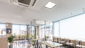 A modern restaurant with a high ceiling, large windows, and a clean, tiled floor. - Hotel HORAIRE Saijo (Saijo)