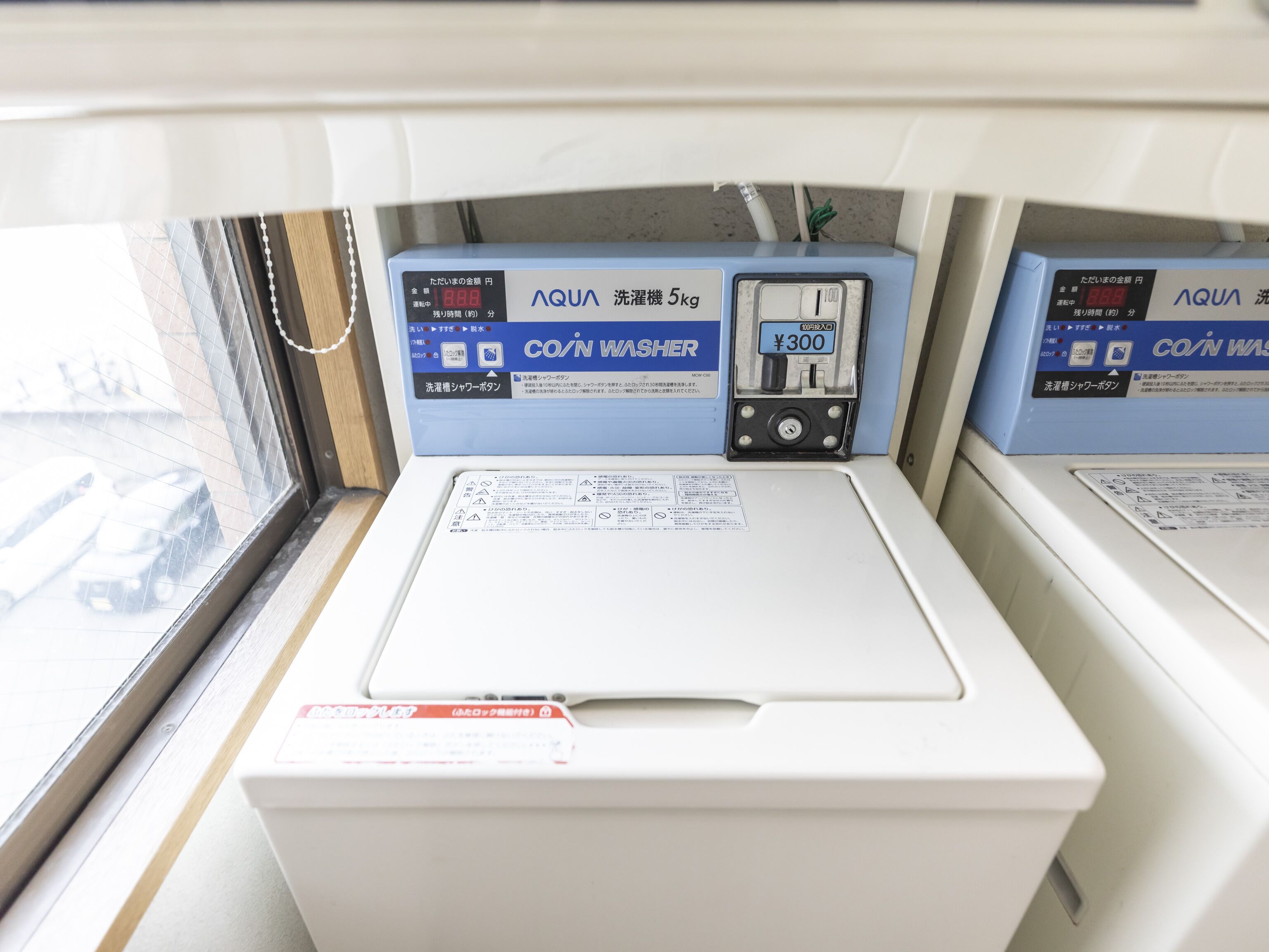 A wash machine with a digital display and a price tag of ¥300.