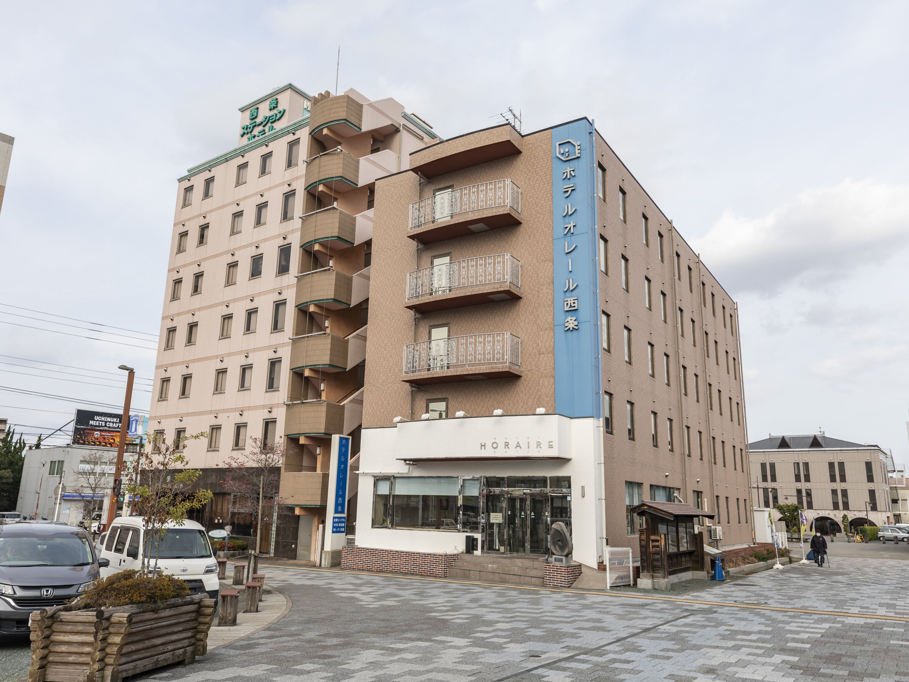 A multi-story hotel with a modern design, featuring balconies on the upper floors and a visible entrance with glass doors.