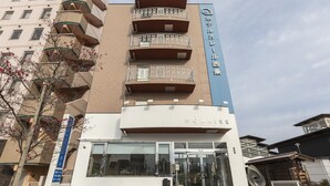 A hotel with a modern design, featuring a prominent entrance with glass doors and a visible name sign. - Hotel HORAIRE Saijo (Saijo)