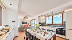 Una cocina moderna con comedor, ventanas amplias y vistas al exterior.