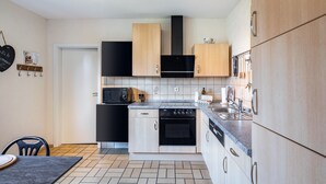 A modern kitchen with a microwave, oven, and dishwasher. - Holiday Apartment "Kirchheim" with Private Terrace, Private Garden and Wi-Fi (Kirchheim)