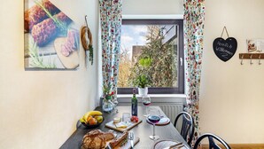 A dining table with food, wine, and a view of the outdoors. - Holiday Apartment "Kirchheim" with Private Terrace, Private Garden and Wi-Fi (Kirchheim)