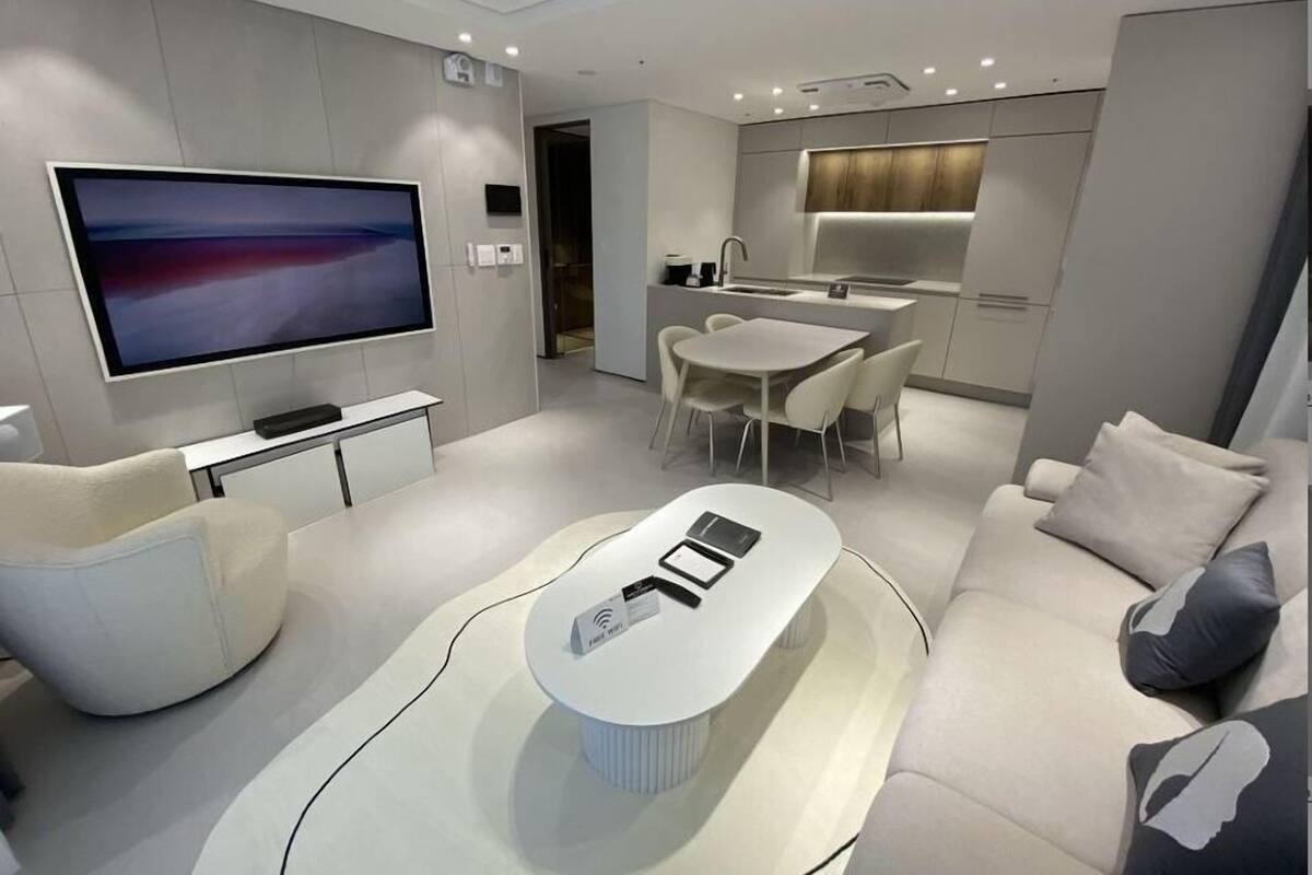 Een moderne woonkamer met een flatscreentelevisie, een eethoek en een keuken.