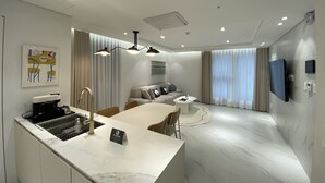 Un salon moderne avec un canapé, une table basse et un coin repas.