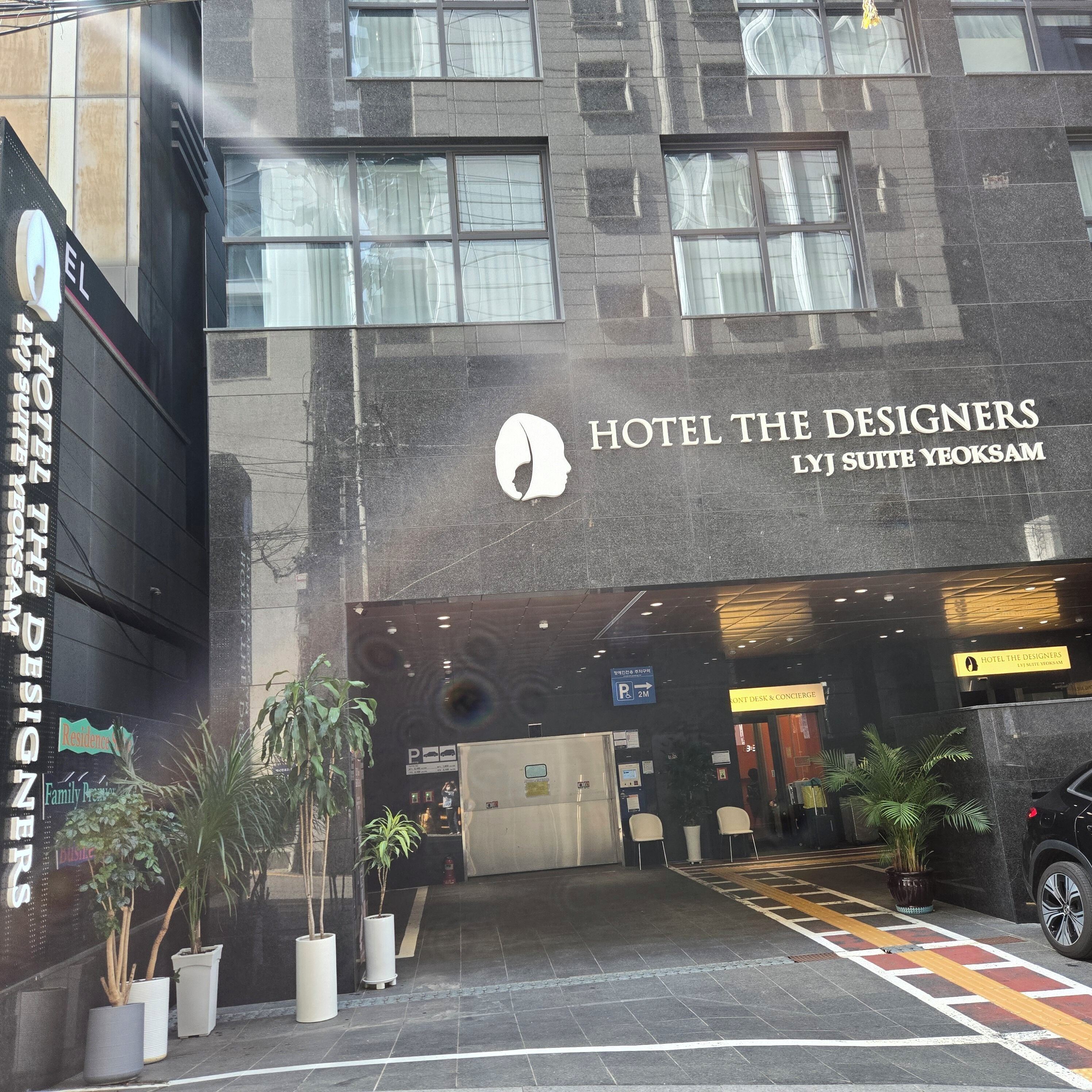 En hotelindgang med et skilt, der viser 'Hotel The Designers L.J Suite Yeoksam'.