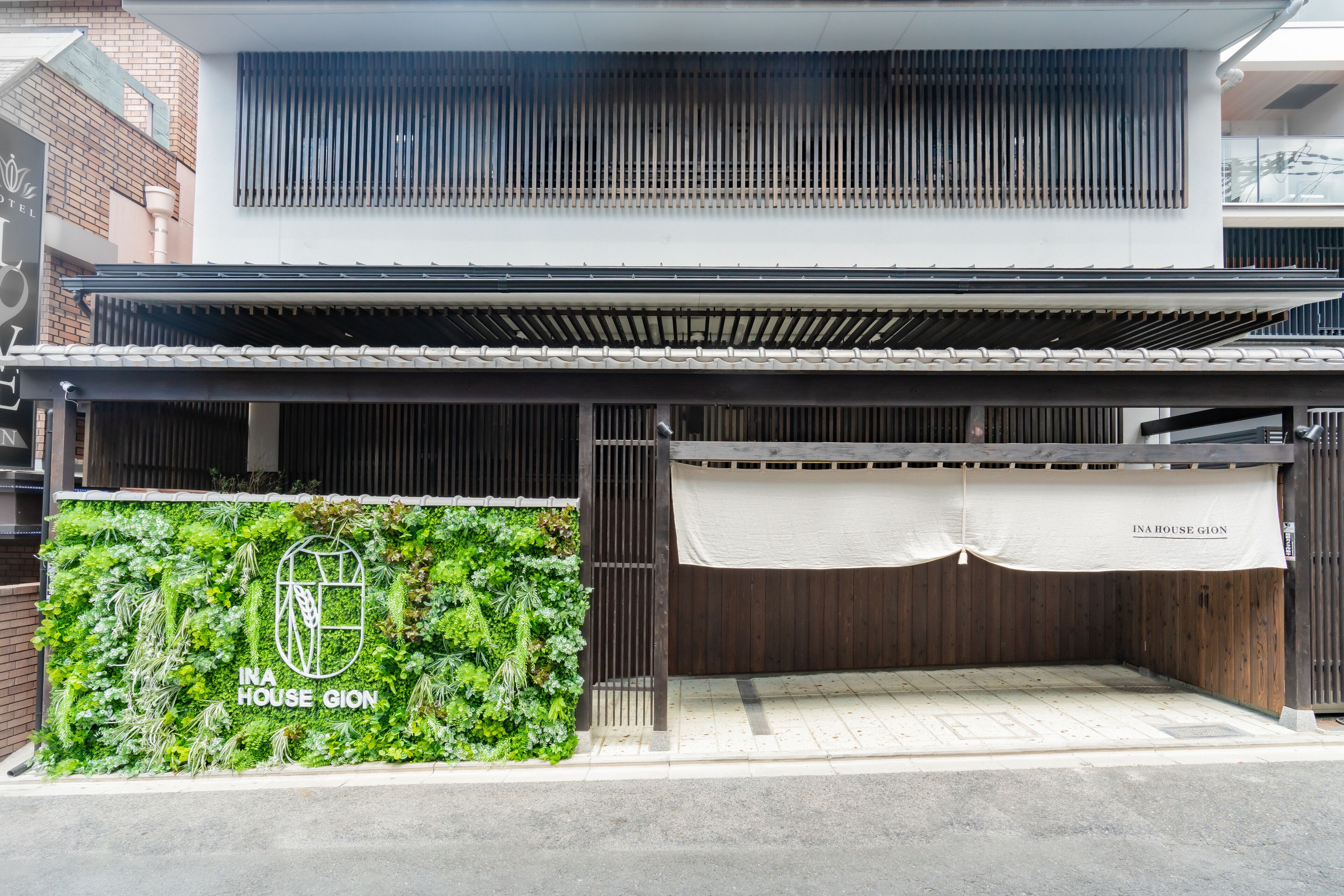 A modern building with a green wall and a white awning.