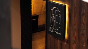 Puinen seinä, jossa on kyltti, jossa lukee: ”INA HOUSE GION”.