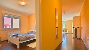 Ein modernes Schlafzimmer mit einem Bett, einem Heizkörper und einem Fenster mit Jalousien.
