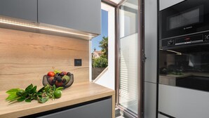 Una cocina moderna con encimera de madera, cesta de frutas y horno Bosch.