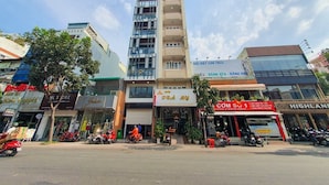 Un edificio de varios pisos con diversas tiendas en la planta baja, incluyendo un letrero visible que dice 'COM SU 1'.