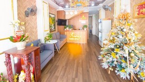 Un vestíbulo de hotel con mostrador de recepción, sofás, un árbol de Navidad y una araña.