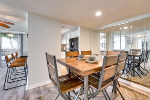 Enjoy meals in this stylish dining area with a wooden table and matching chairs, surrounded by a clean, minimalist design.