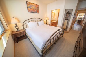 A bedroom with a bed, two bedside tables with lamps, a dresser, a mirror, and a painting on the wall. - Settlers Creek 6528 (Keystone)