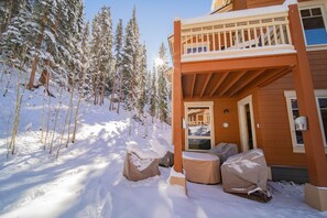 A wooden cabin with a covered porch, snow-covered trees, and a clear sky. - Settlers Creek 6528 (Keystone)