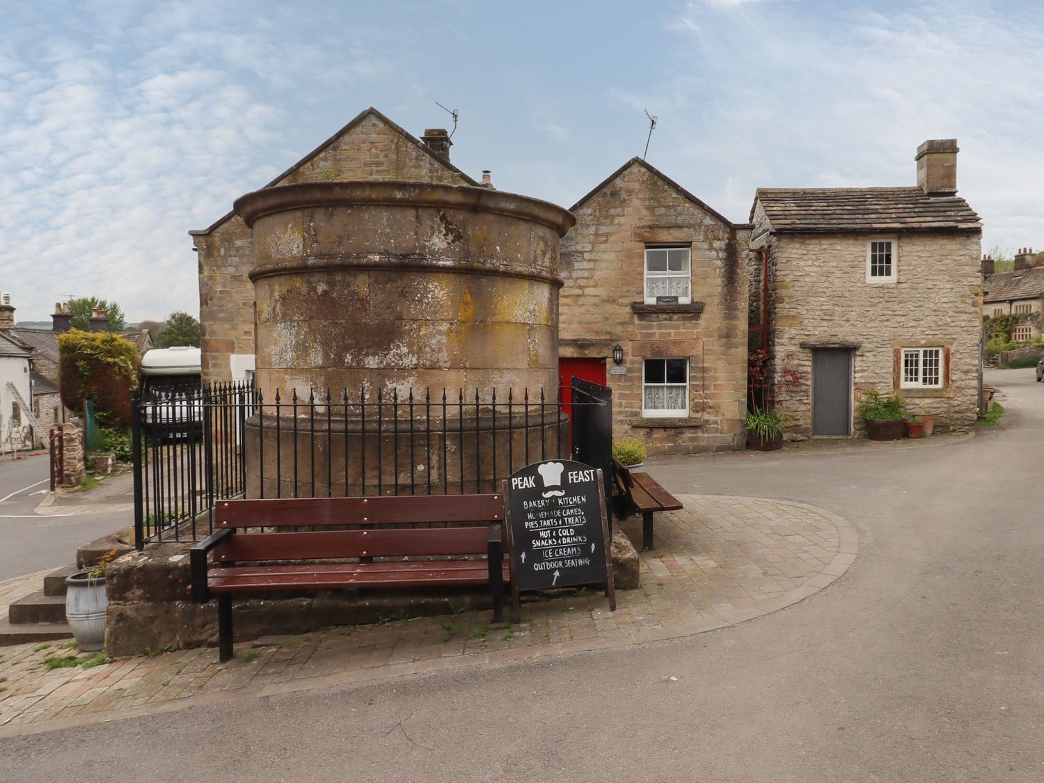 A traditional stone building with a signboard advertising a bakery and kitchen.