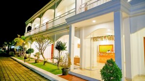 Un hôtel à la structure de deux étages, doté d’un espace de réception avec un comptoir et d’un balcon agrémenté de balustrades.