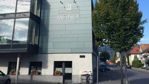 Un edificio moderno con facciata in vetro e un cartello con scritto "MEINDL".