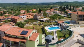 Ett bostadsområde med hus, en swimmingpool och utsikt över de omgivande kullarna.