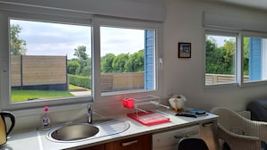 A modern kitchen with a large window, a sink, and a dishwasher.
