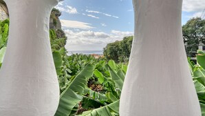A view through a white structure with a clear sky and distant landscape. - Villa Rosa, a Home in Madeira (Funchal)