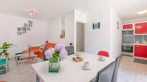 Un appartement moderne comprenant un coin repas, un salon et une cuisine.