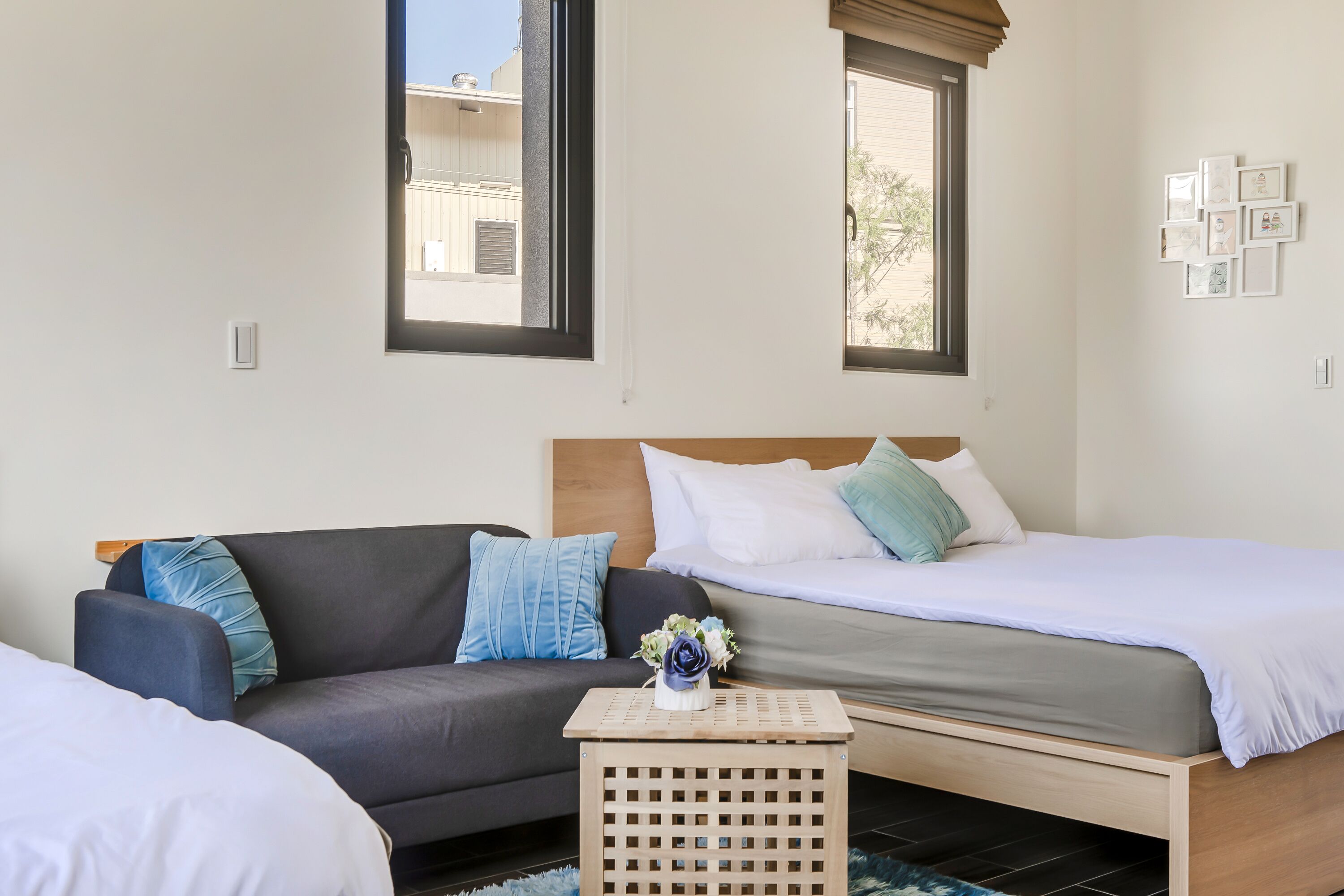 A bedroom with a bed, a sofa, and a small table with a vase.