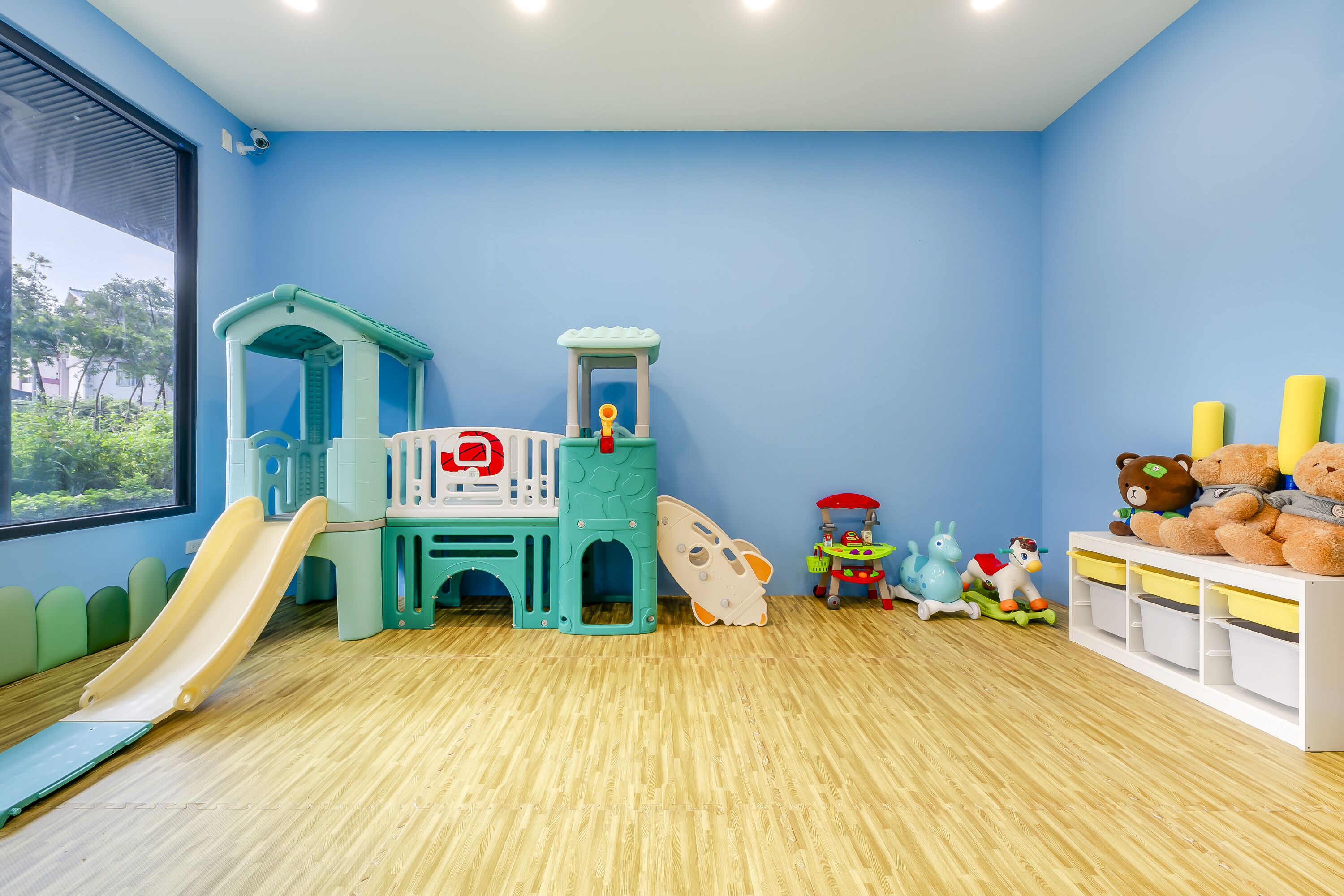 A play area with a slide, a playhouse, and various toys.