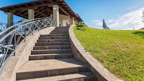 A stone staircase leading to a covered area with a metal railing, surrounded by grass and a clear sky. - Pet friendly home in Visnjan with WiFi (Visnjan)