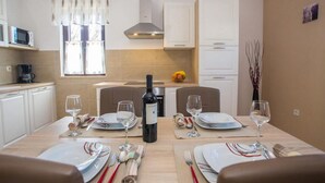 A dining area with a table set for two, a bottle of wine, and a fruit bowl on the counter. - Beach front home in Tar-Vabriga (Tar-Vabriga)