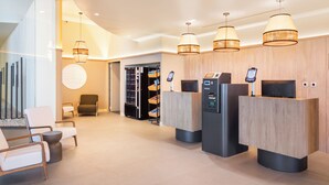 A reception area with modern furniture, a reception desk, and a digital kiosk. - B&B Hotel Olhao Algarve (Olhao)