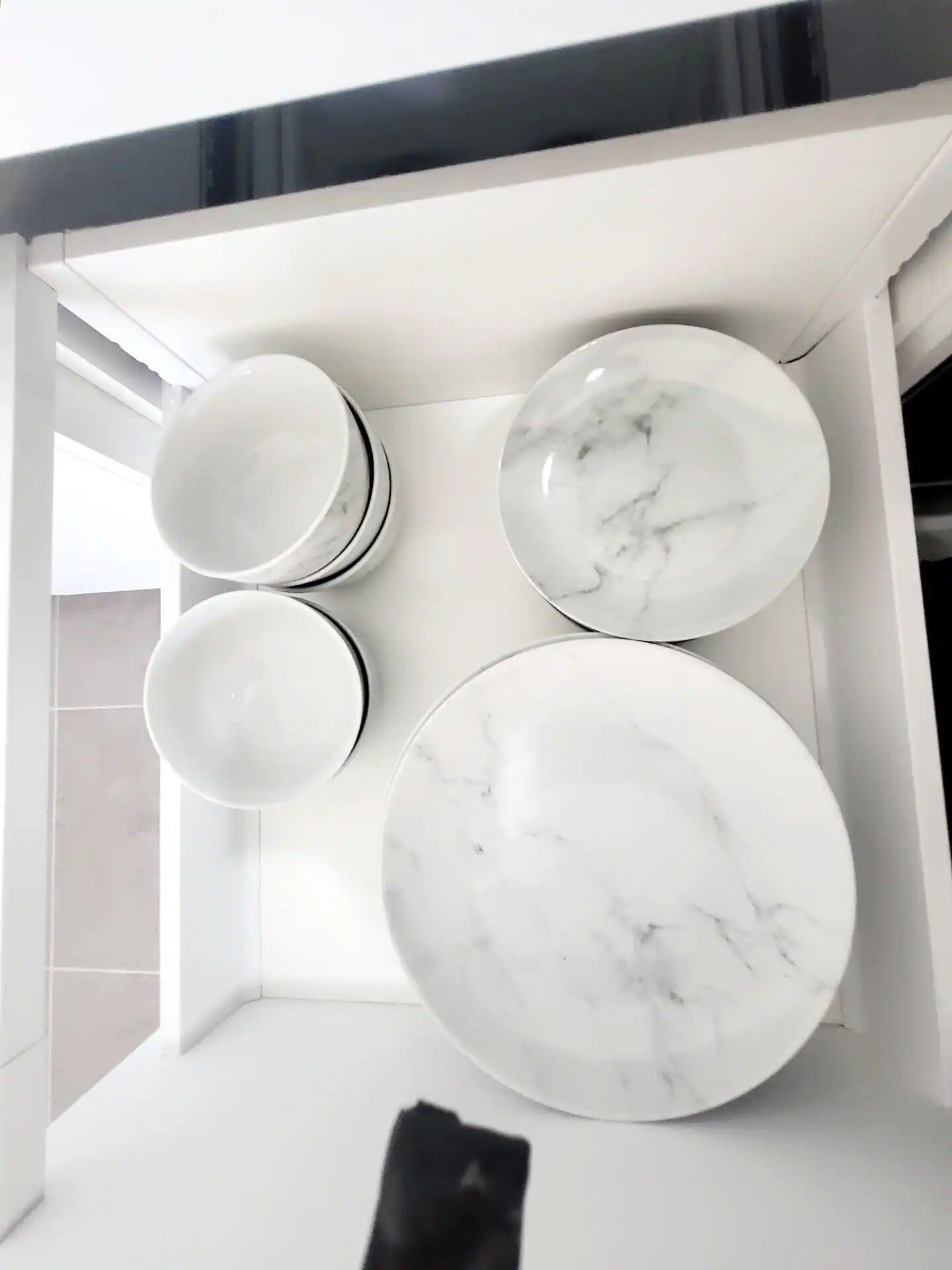 Ett ljust, vitt inre utrymme med modern design, med en vit bänkskiva och en spegel med svart ram.