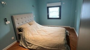 A bedroom with a bed, a window, and a ceiling light. - Appartement-loft de Centre-ville (Montélimar)