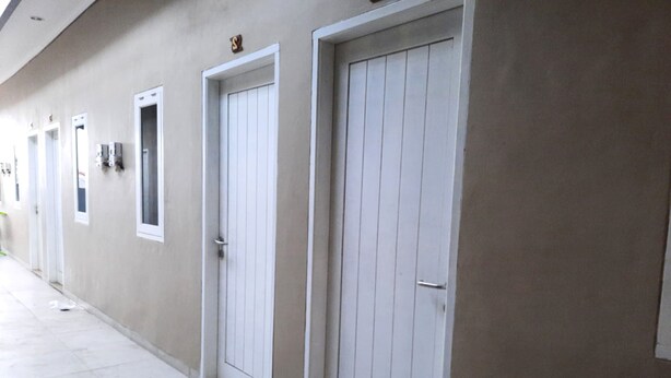 Un couloir avec des portes et des fenêtres, ce qui laisse penser qu’il pourrait s’agir d’un hôtel ou d’un immeuble d’appartements.